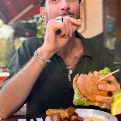 ein Mann mit Burger in einem Restaurant sitzend